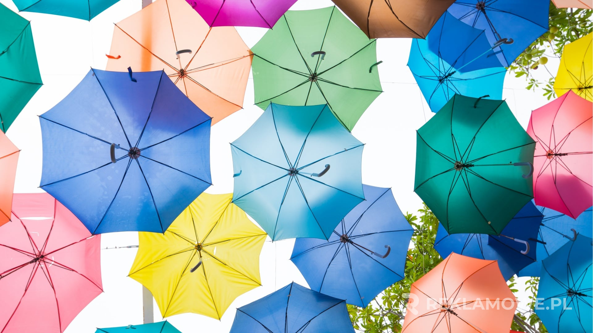Kolorowy parasol reklamowy rozwinięty na tle nieba