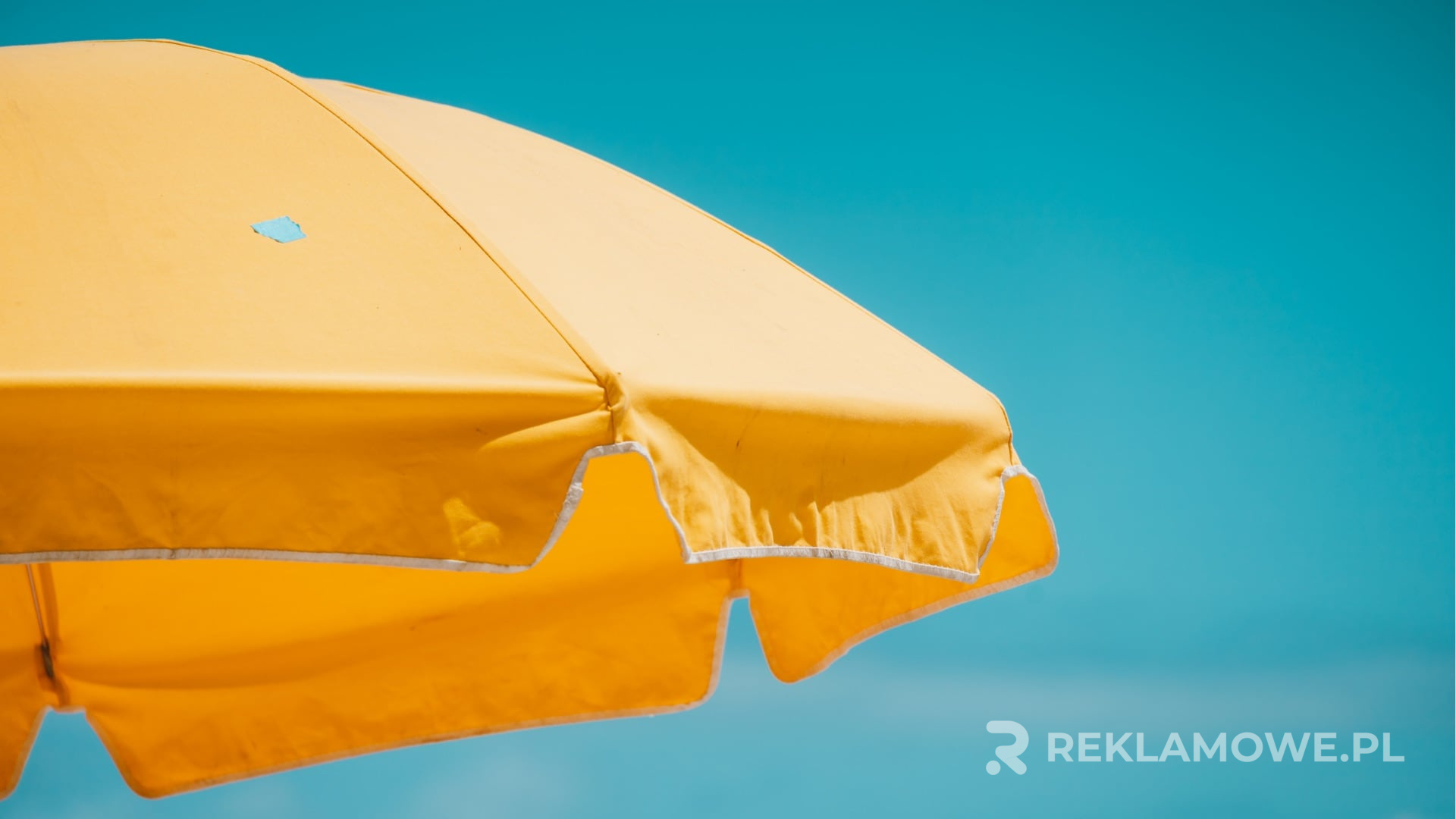 Kolorowe parasole reklamowe ułożone na tle miejskiego krajobrazu